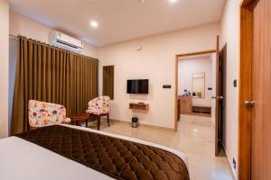 a hotel room with a bed and a television at Airport Haven in Ernakulam