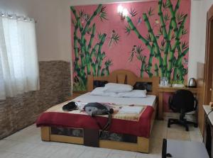 a bedroom with a bed with a painting on the wall at Green Balley Resort On Beach in Mandarmoni