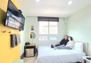 a man and woman sitting on a bed in a room at Hostel Tommy Renewal 2025 in Seoul +57 photos