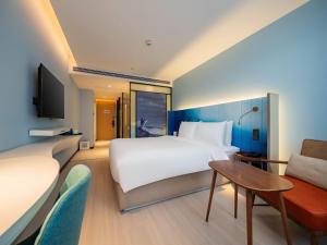 a hotel room with a bed and a couch at 西安北站市政府漫心酒店 in Xi'an