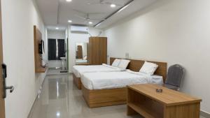 a bedroom with a bed and a table in it at SRI HARSHA AC Luxury rooms in Warangal