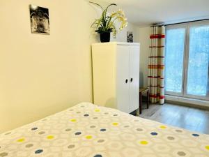 ein Schlafzimmer mit einem Bett und einem Schrank mit einer Pflanze darauf in der Unterkunft Le Bon Repos - Séjours professionnels et vacances en famille aux portes de Paris in Garches