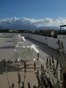 a group of white chairs sitting on top of a roof at Aeolos Hotel Apartments in Gythio
