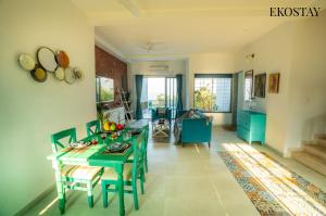 a living room with a green table and chairs at EKOSTAY - Eternal Wave in Lonavala