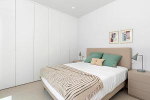 a bedroom with a large bed with white walls at Villa Buba in Pilar de la Horadada +10 photos