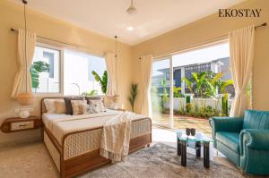 a bedroom with a bed and a couch and a window at EKOSTAY - Azure Villa in Lonavala +25 photos