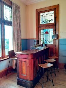 a kitchen with a wooden island in a room with windows at Noah's Ark Backpackers in Greymouth +63 photos