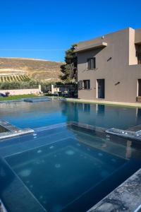 a swimming pool in front of a building at Orion Eco Suites in Karteros