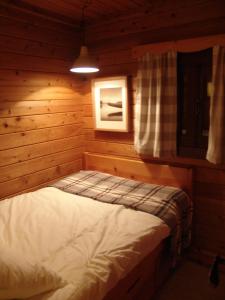 um quarto com uma cama num chalé de madeira em Cabana de Santo António em Vila Nova de Cerveira