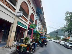 a group of people sitting at tables on a city street at XX Mitr Inn - Phuket Old Town in Phuket