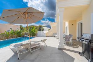 un patio con sombrilla, sillas y piscina en CostaBlancaDreams Bernia Views in Calpe, en Empedrola