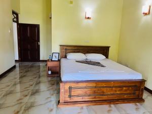 a bedroom with a large bed with a wooden frame at Lihini Scandic in Seeduwa