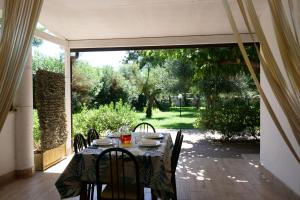 a table and chairs on a patio with an open door at Residence Oasis Punta Prosciutto in Punta Prosciutto