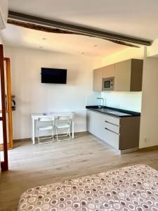 Habitación con cocina y mesa con 2 sillas. en Belvedere Home Holiday, en Corniglia