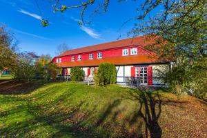 a red barn with a red roof at Piratenkajüte-B66 in Dranske +9 photos