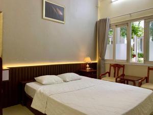 头顿林宋酒店的一间卧室，有一张白色的床和一扇窗户 更多63张照片