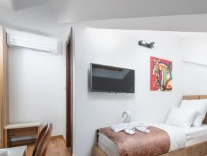 a bedroom with a bed with a tv on the wall at Hotel Dua Residence in Poreč