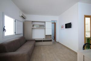 a living room with a couch and a window at Residence Oasis Punta Prosciutto in Punta Prosciutto