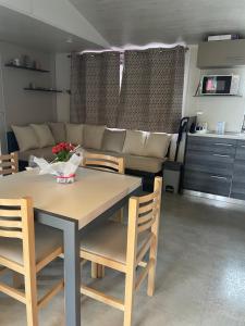 a living room with a table and chairs and a couch at Mobil home 6-8pers - Le lac des rêves in Lattes