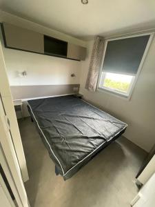 a bed in a room with a window at Mobil home 6-8pers - Le lac des rêves in Lattes +6 photos