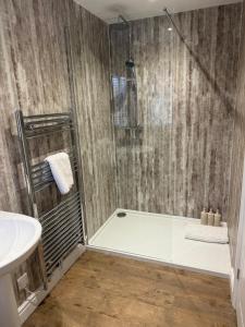 a bathroom with a shower and a toilet and a sink at Sea Views Oddfellows in Pakefield +32 photos