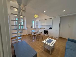 a living room with a kitchen and a spiral staircase at Blu Celeste in Porto Santo Stefano
