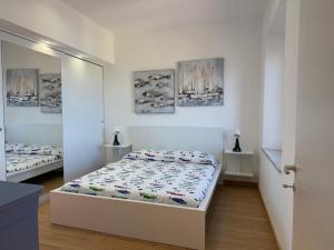 a bedroom with two beds and paintings on the wall at Blu Celeste in Porto Santo Stefano