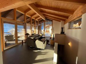 un salon avec des canapés et une grande fenêtre dans l'établissement Schöneben Chalet Ferienwelt, à Wald im Pinzgau