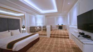 a bedroom with a large bed and a flat screen tv at The Grantage Hotel & Sky Lounge in Serpong +54 photos