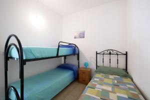 a bedroom with two bunk beds and a night stand at Residence Oasis Punta Prosciutto in Punta Prosciutto
