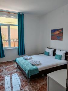 a bedroom with a large bed and a window at Къща за гости Пиргос in Burgas