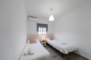 two beds in a room with white walls at Apartamento Vela in San José