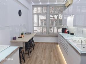 a kitchen with white counters and a large window at AS luxury apartment in Athens