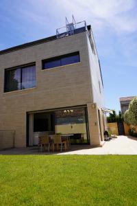 ein Gebäude mit einem Tisch und Stühlen davor in der Unterkunft complete luxury house with garden in Madrid