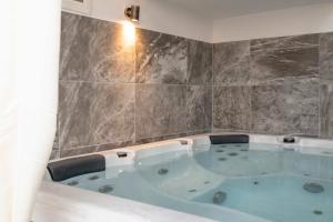 a jacuzzi tub in a corner of a bathroom at Cleopatra deluxe with jacuzzi apart in Kamilari with panoramic view in Kamilari +36 photos