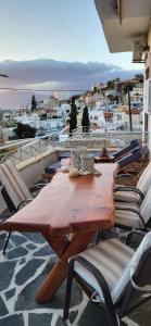 a wooden table and chairs on top of a balcony at Cleopatra deluxe with jacuzzi apart in Kamilari with panoramic view in Kamilari