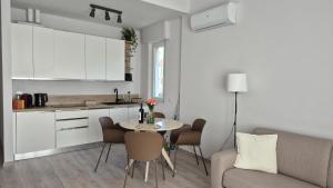 a living room with a table and a kitchen at Lake Como House in Como