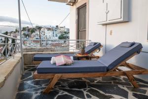 a balcony with two lounge chairs on a balcony at Cleopatra deluxe with jacuzzi apart in Kamilari with panoramic view in Kamilari