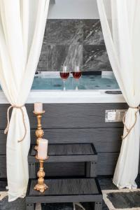 two glasses of wine sitting on a bath tub at Kleopatra Deluxe Apt with priavte Jacuzzi in Kamilari