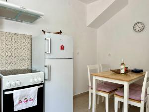 a kitchen with a white refrigerator and a table at Casa Di Rosse in Symi