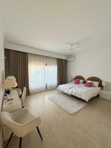 a bedroom with two beds and a table and a chair at Villa Casa La Concha - Luxury 6 bedroom Villa in Marbella, Beautiful Mountain View, Heated Swimming Pool, 15min walk to Puerto Banus Beaches, Sleeps up to 12 in Marbella +21 photos