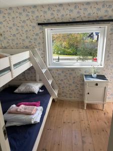 a bedroom with a bunk bed and a window at Cozy cottage by the sea, near Kullaberg in Farhult