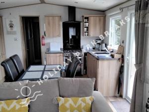 a kitchen with a couch and a table in a kitchen at Valeria - Gold 3 bedroom with Garden and Parking - Seal Bay in Selsey