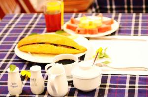ホイアンにあるGold Stone Hoi An Homestayのテーブルの上に食べ物の皿が置かれたテーブル
