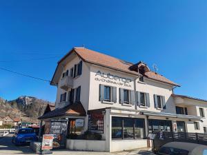 een groot wit gebouw met een bord erop bij Auberge du château de Joux in La Cluse et Mijoux