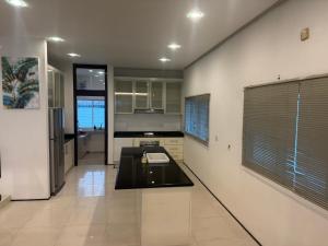a kitchen with white walls and a black counter top at Bungalow Perkasa in Kuala Lumpur