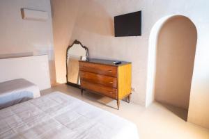a bedroom with a bed and a dresser with a mirror at CASA FLORA - Noto in Noto