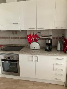 a kitchen with white cabinets and a counter top at Arminda in Arguineguín