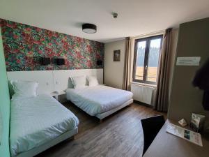 een hotelkamer met twee bedden en een raam bij Auberge du château de Joux in La Cluse et Mijoux