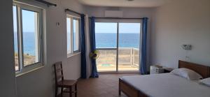 una camera da letto con un letto e vista sull'oceano di Cacimba Sunset Lodge a Tarrafal